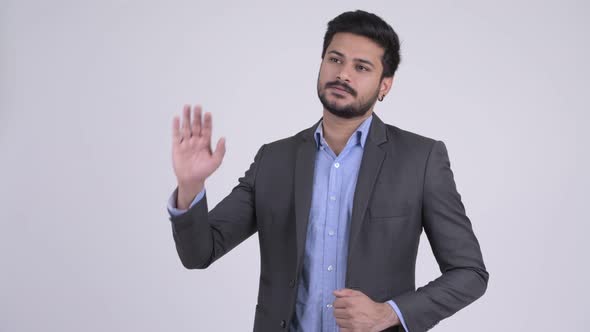 Young Handsome Bearded Indian Businessman Waving Hand