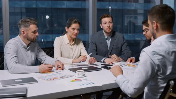 Corporate team interviewing a job candidate sitting at desk