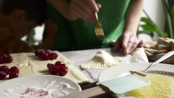 Mother cooking homemade cookies with cherry at home