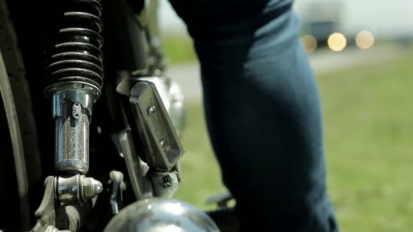 Two male person feets on a motorcycle during sunny day in nature,close up