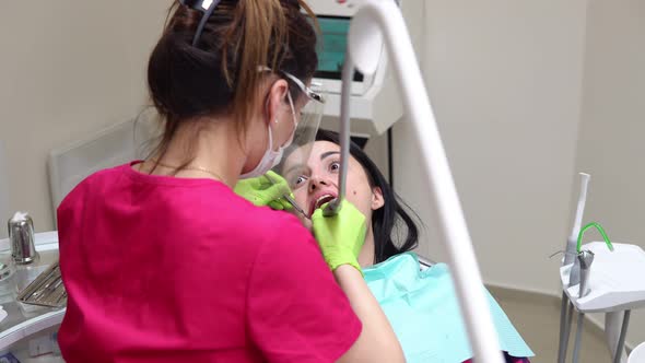 Dentist Cleans Woman's Teeth with Professional Toothpaste and Automatic Brush