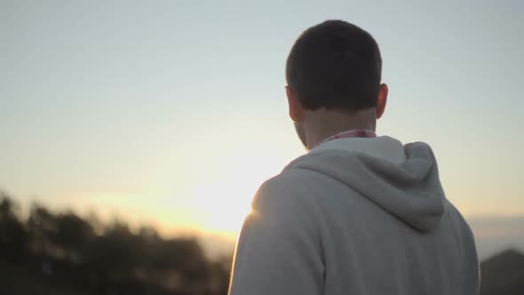 Back View of Young Man Looking at Panorama in Nature Mountain Outdoor at Sunrise or Sunset