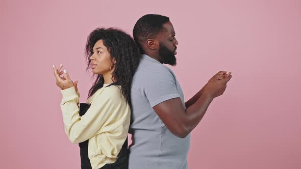 Unsure African American Man and Woman Standing Back to Back Comparing Variants Counting on Fingers