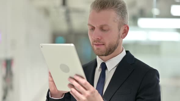 Portrait of Attractive Young Businessman Using Digital Tablet