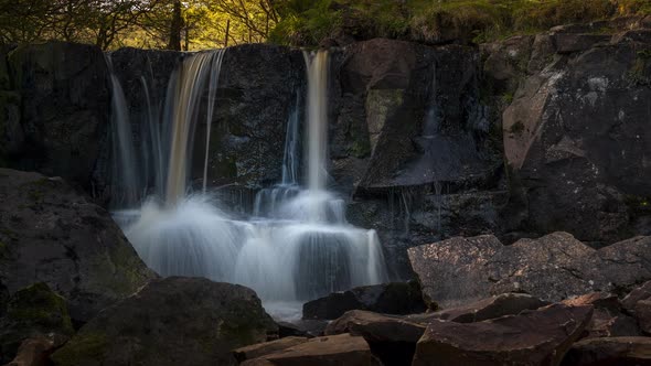 Time lapse of local waterfall in rural forest landscape of Ireland on a summer sunny day. alt