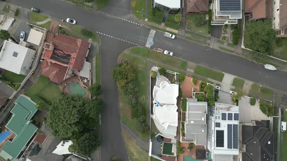 Top down aerial of a quiet residential properties and town houses street intersections. Homes with c