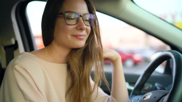 Portrait of a Beautiful Girl with Glasses in the Car
