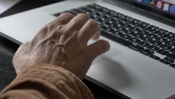 man types some text on laptop keyboard