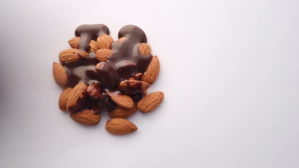 Dark Chocolate Cream Pouring on Almond Nut on White