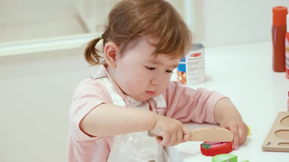 Image Of An Adorable Toddler Plays With Wooden Cutting Vegetables Toys. Close Up