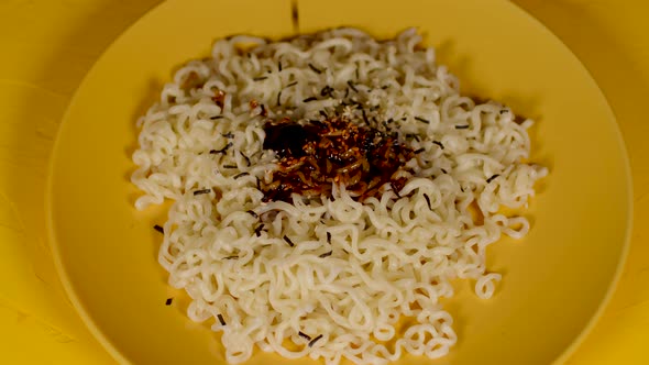Readymade Instant Noodles with Condiment in Yellow Plate on Yellow Background
