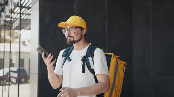 Portrait of Smiling Courier Using Cellphone