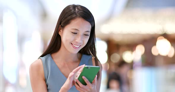 Asian young woman use of mobile phone  inside shopping center