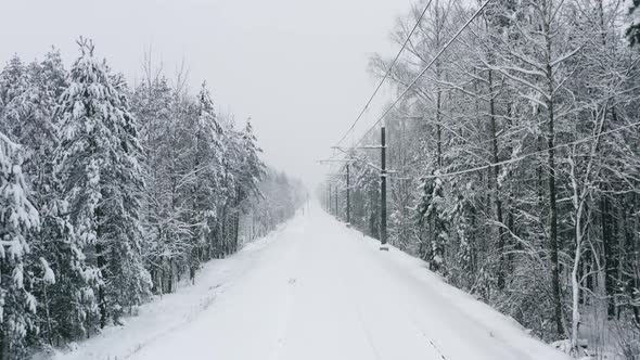 Aerial View Drone Flies Over Snow Covered Railway Track in Winter Forest