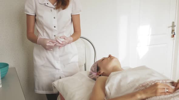 A Masseur Gives a Woman a Professional Facial Massage