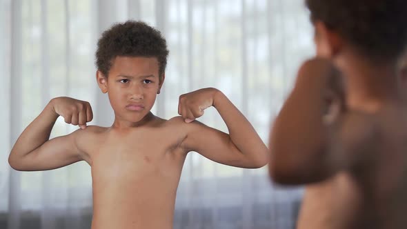 Unhappy Little African American Boy Looking in Mirror, Suffering Insecurities