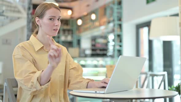 No Finger Gesture By Young Woman with Laptop in Cafe