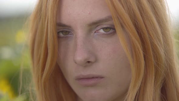 Close-up Portrait of Young Confident Girl with Red Hair and Green Eyes Looking at the Camera