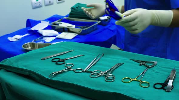 Scrub nurse preparing medical instruments for operation