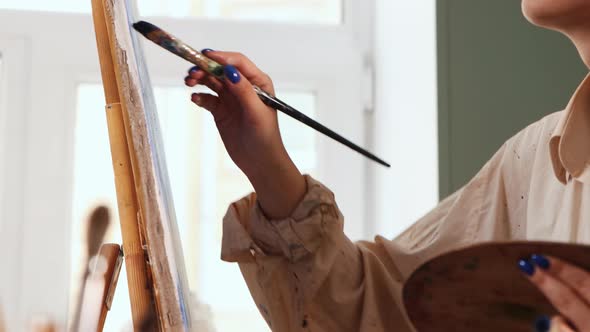 Art Studio  Woman Artist in White Color Stained Shirt Drawing a Painting