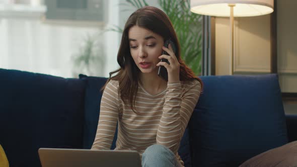 Attractive Young Woman is Speaking on Smartphone with Client From Home