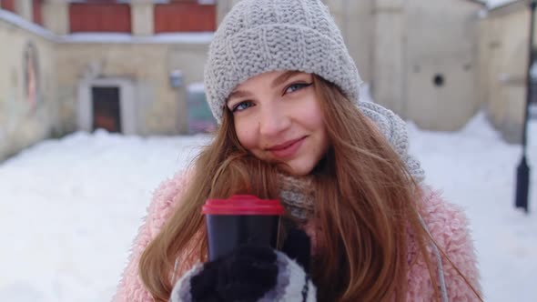 Stylish Woman Traveler with Hot Drink in Cup Looking Around Through City Street During Vacations