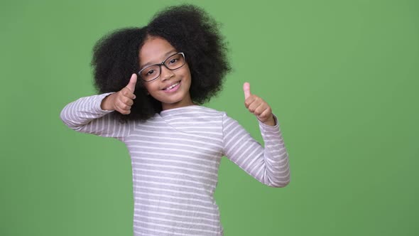 Young Cute African Girl with Afro Hair Giving Thumbs Up