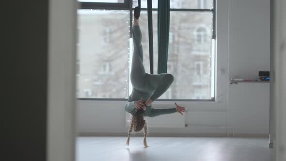 A Young Beautiful Woman Performs Exercises on a Hammock From Aero Yoga