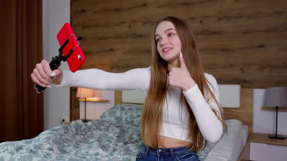 Smiling Cute Vlogger Girl Looking at Mobile Make Video Call Shooting Vlog Taking Selfie at Home