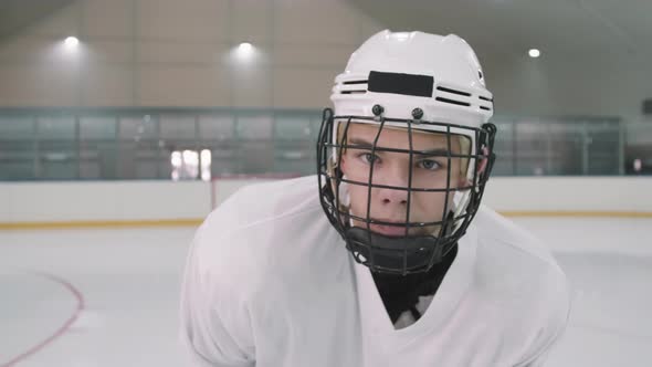 Young Male Hockey Player In Helmet With Cage