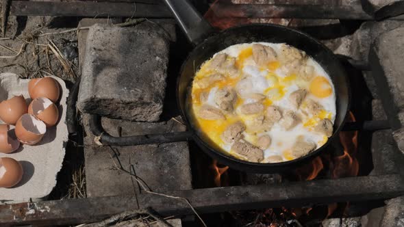 Cooking Scrambled Eggs with Chicken Meat on Tourist Campfire Frying Pan Nature