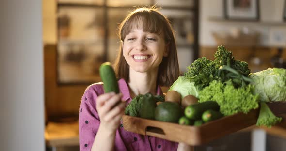 Portrait of a Woman Holding Fresh Vegetables and Greens at Home