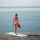 Yoga Woman in Red Sport Costume Doing Asana Near Sea - VideoHive Item for Sale