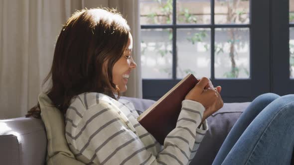 Mixed race woman reading a book. Social distancing and self isolation in quarantine