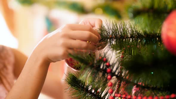 Closeup Video of Female Hands Hanging Colorful Bauble on Christmas Tree