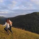 A Young Couple Runs Happily Along a Mountain Path - VideoHive Item for Sale