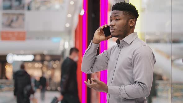 Young African American Man Standing in Mall Talking on Mobile Phone Answering Business or Friendly