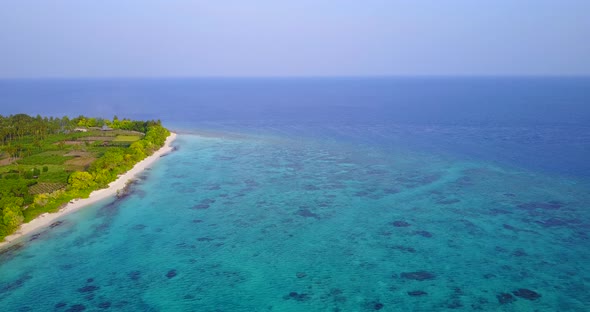 Wide angle drone abstract view of a white sand paradise beach and blue water background in 4K