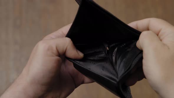 A Man Throws an Empty Leather Wallet on the Ground Closeup