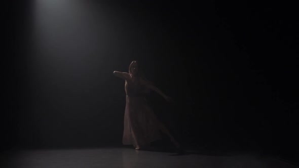 Woman Practicing Contemporary in Dark Studio Under Spotlight. Slow Motion