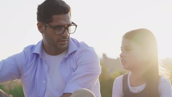 Close Up Portrait of Father and Daughter Talking Outdoors at Sunset