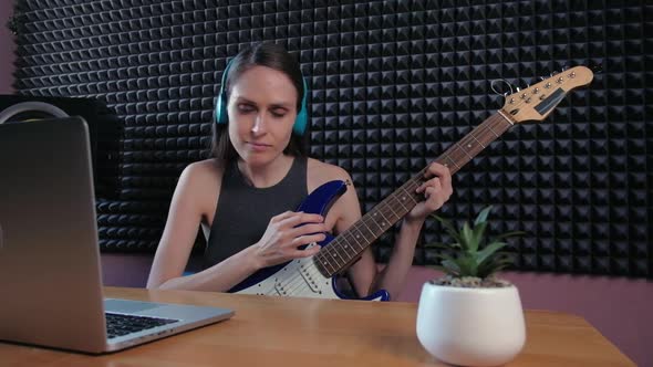 Female Learning Play Guitar at Home Using Online Lessons