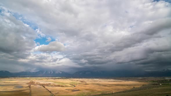 Thick clouds moving in timelapse as the sun lights up the golden landscape