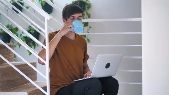 Young Man Freelancer Student Using Laptop Studying Online Working From Home in Internet Smiling