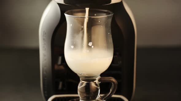 Milk pouring into fancy glass cup