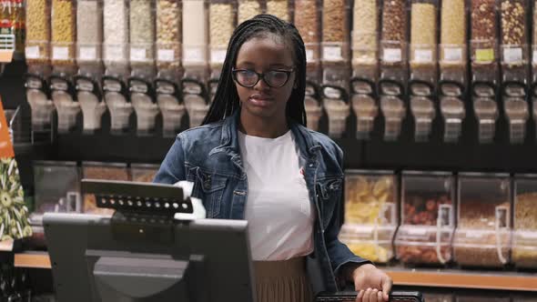 African American Costumer Putting Vegetables on Scale in Supermarket