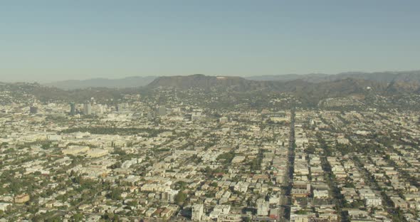 Aerial helicopter shot, push in on snowy mountain peak to reveal rocky mountain valley lurking below