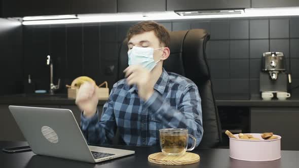 Person takes off protective mask after online work at home. 