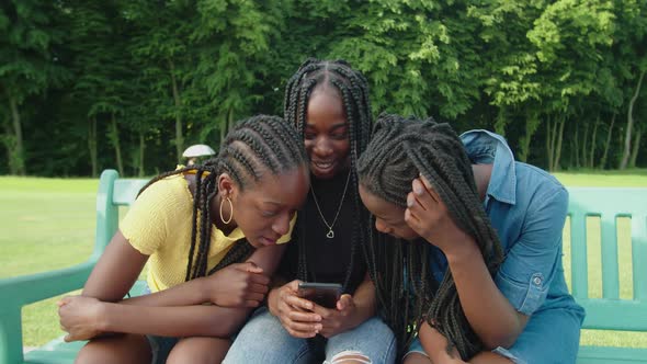 Lovely African Teenage Girls Watching Social Media Content Online on Phone