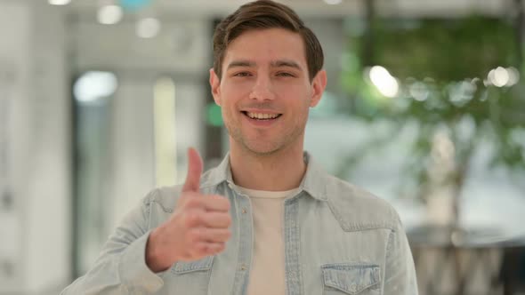 Portrait of Creative Young Man Showing Thumbs Up Sign